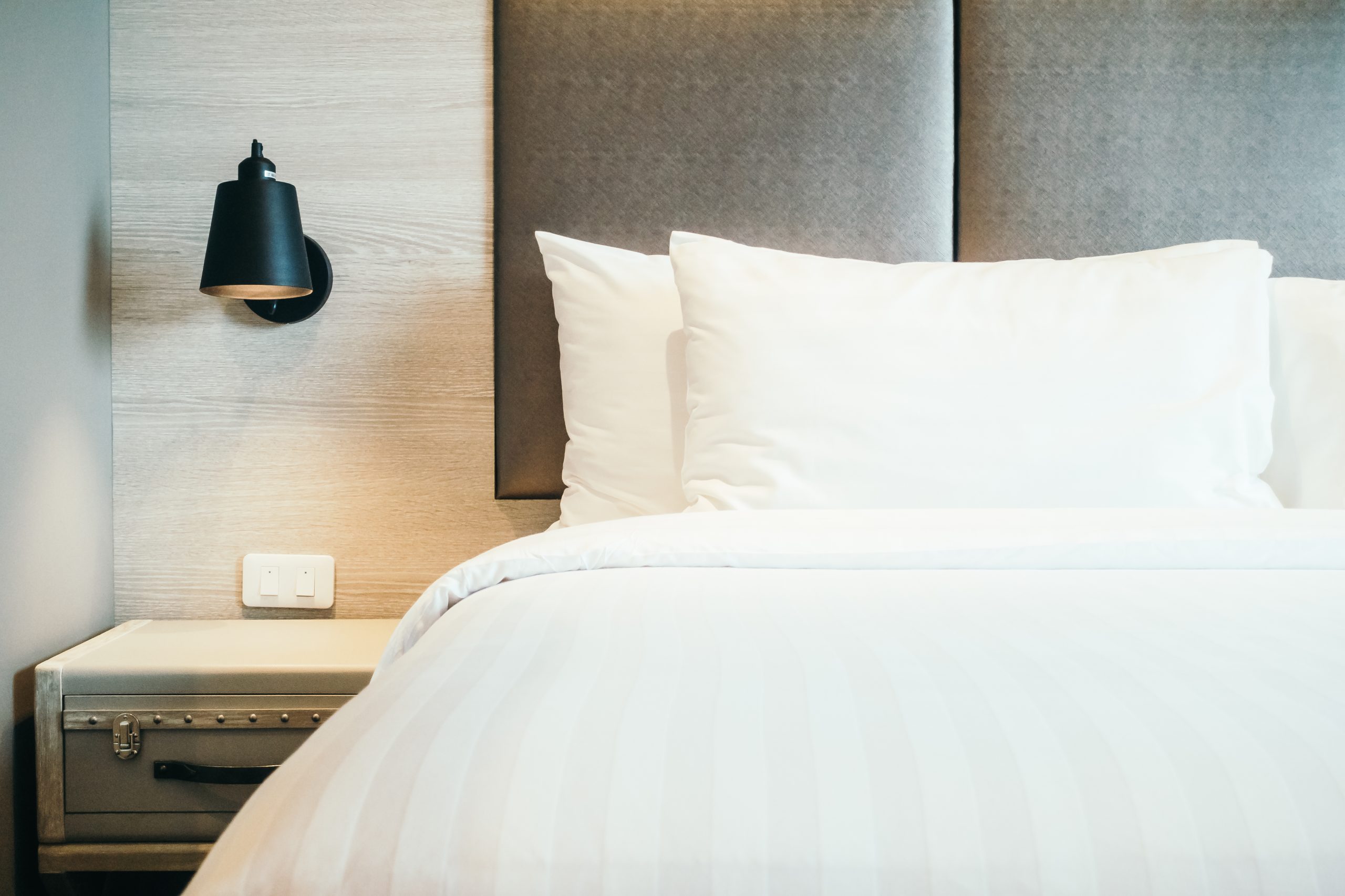 Lit d'hôtel propre avec oreillers blancs, prévention des infestations de punaises de lit dans les hébergements pour les Jeux Olympiques Paris 2024. 