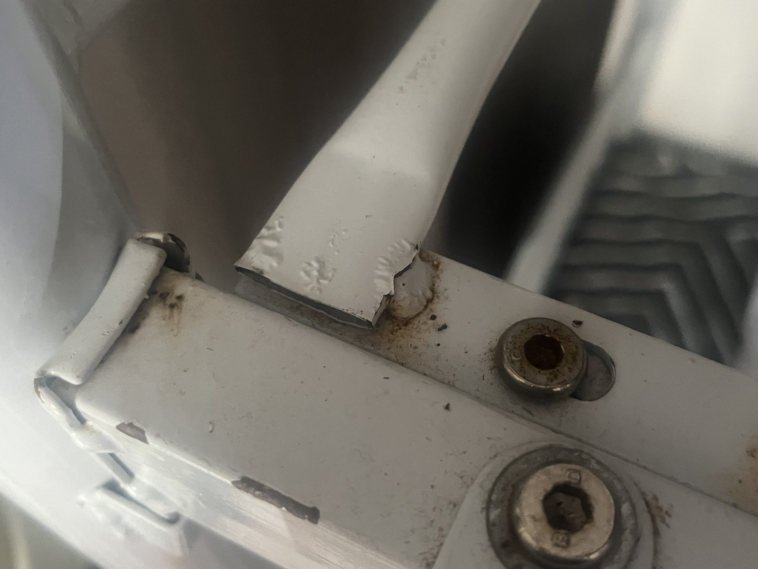 Infestation de punaises de lit près de la structure métallique d'un lit, soulignant leur capacité à se cacher dans des fissures et des objets du quotidien.