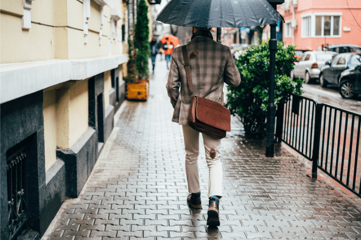 Homme sous la pluie avec une punaise de lit sur son manteau et son pantalon.